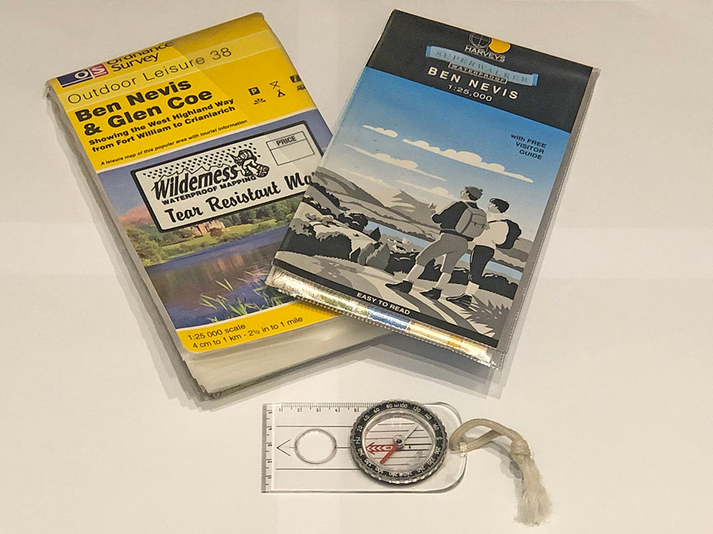 Photo of 1:25,000 walking maps and a compass used for UK hill navigation.