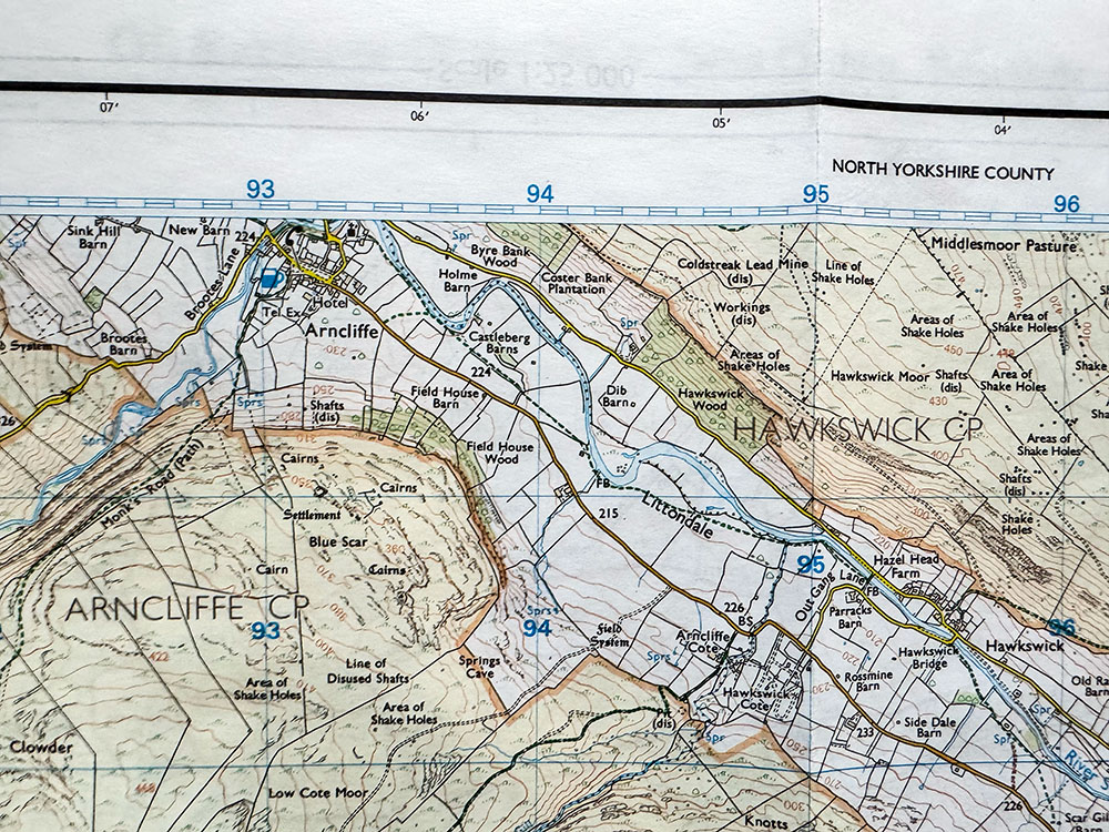 Extract from an Ordnance Survey map showing the faint blue Grid North lines vertically on the map