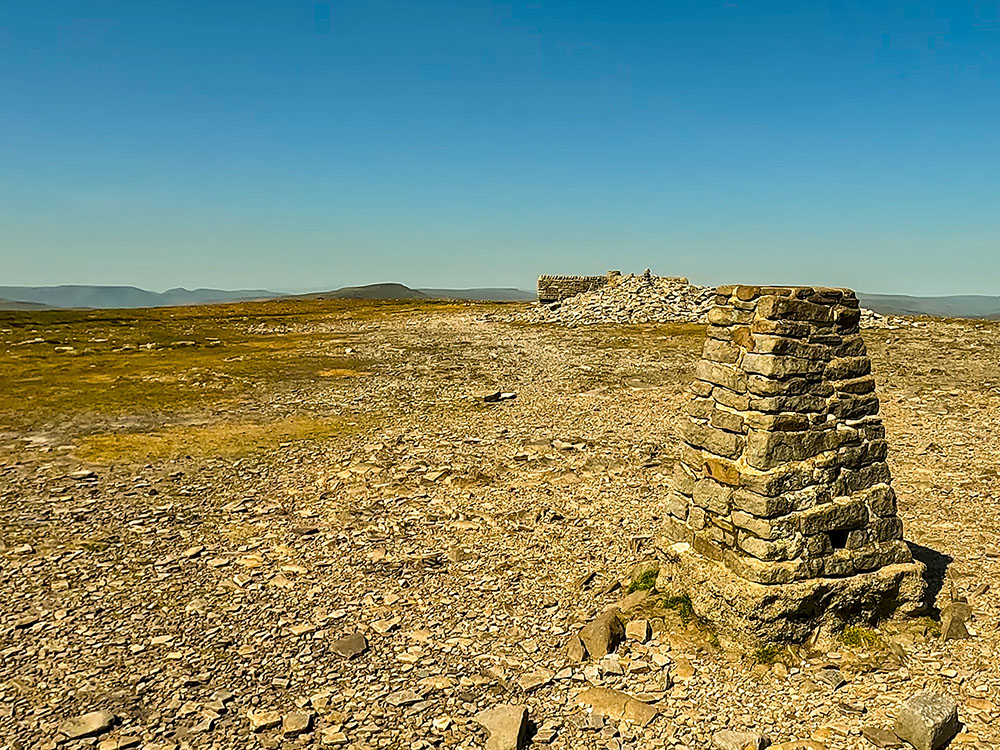 Trig point and weather shelter on the summit of Ingleborough, looking towards Whernside