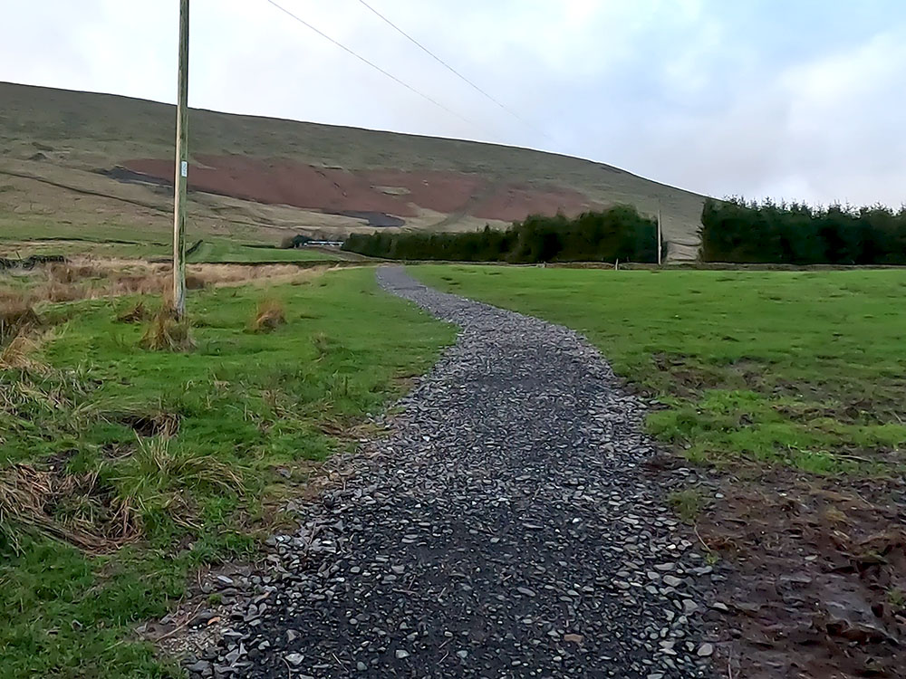 The path heading across fields towards Pendle House before the steps on Pendle Hill