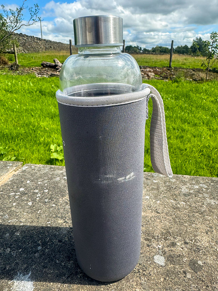A glass water bottle in a silicon sleeve