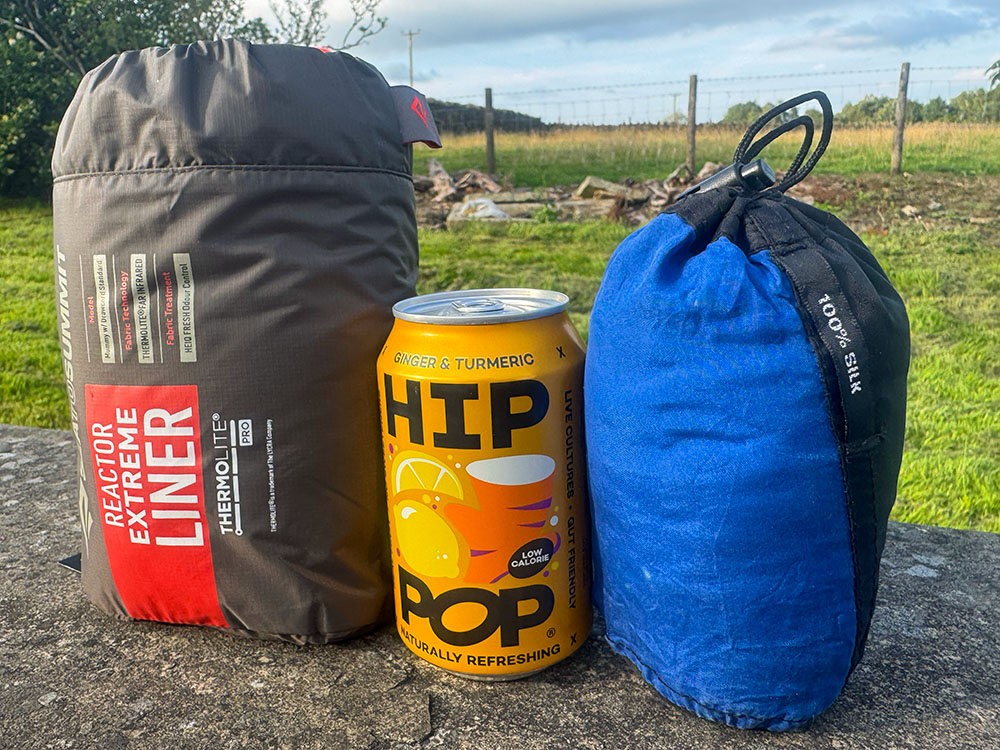 Size comparison between a Sea to Summit Extreme thermal liner, a Cocoon Silk liner and a 330 ml can