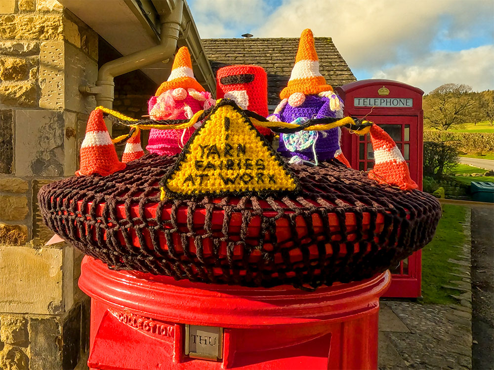 Yarn Fairies at work on top of the post box at the Bolton Abbey Car Park