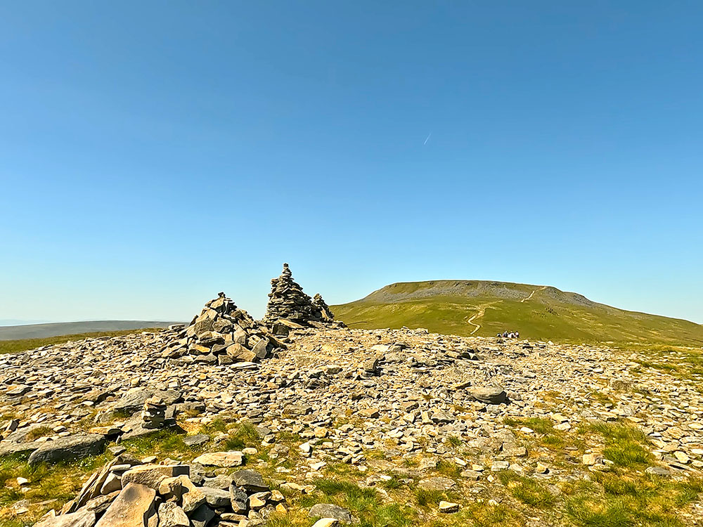 Cairn on Little Ingleborough summit looking out towards the sea and the distant Lakeland Fells