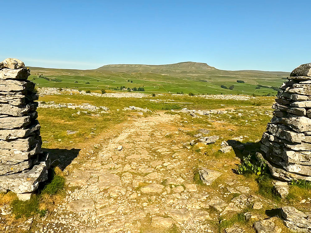 Passing back through the gap in the wall with Pen-y-ghent ahead on the horizon