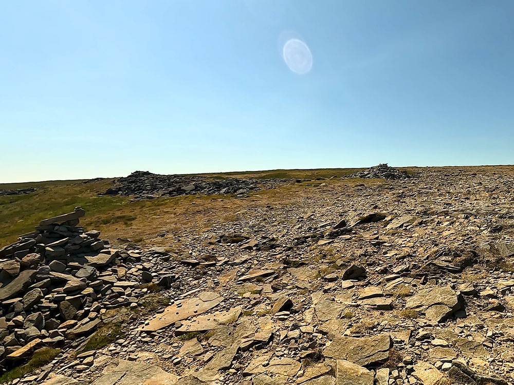 The small cairns on turning left to cross the flat-topped summit plateau on Ingleborough