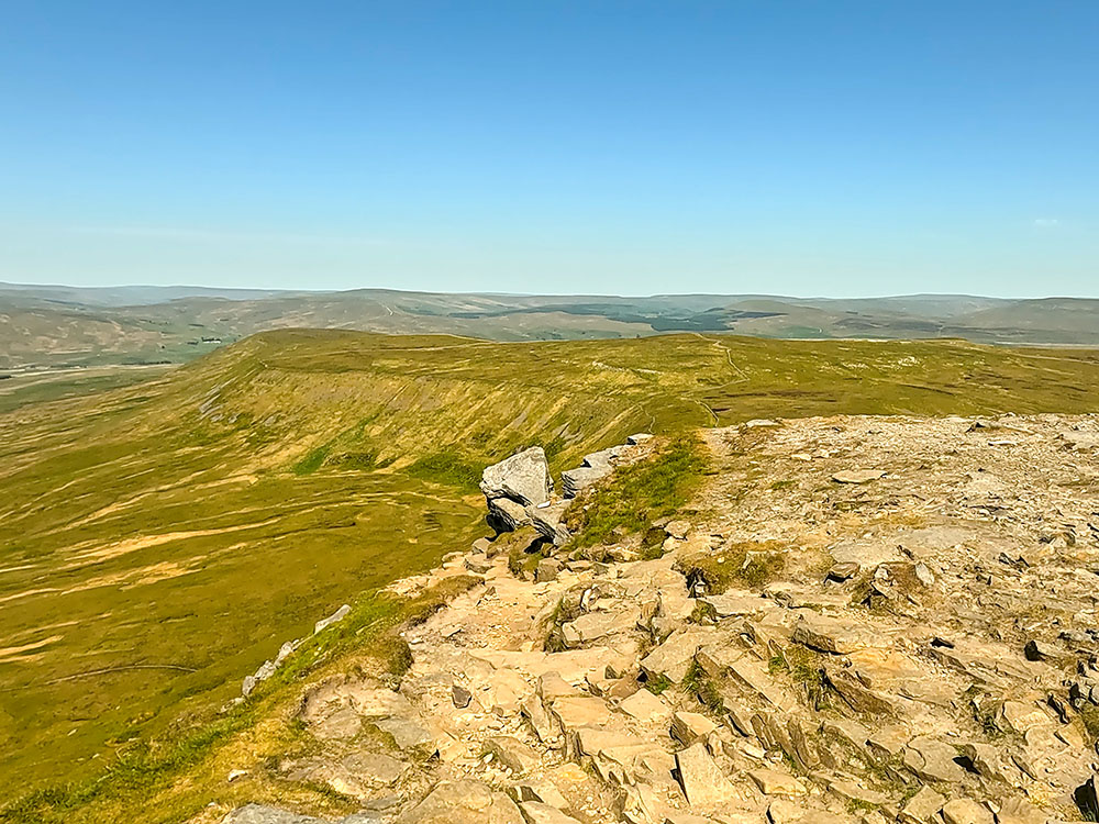 Where the path leaves the summit plateau of Ingleborough to pass down the left-hand side of the large boulder