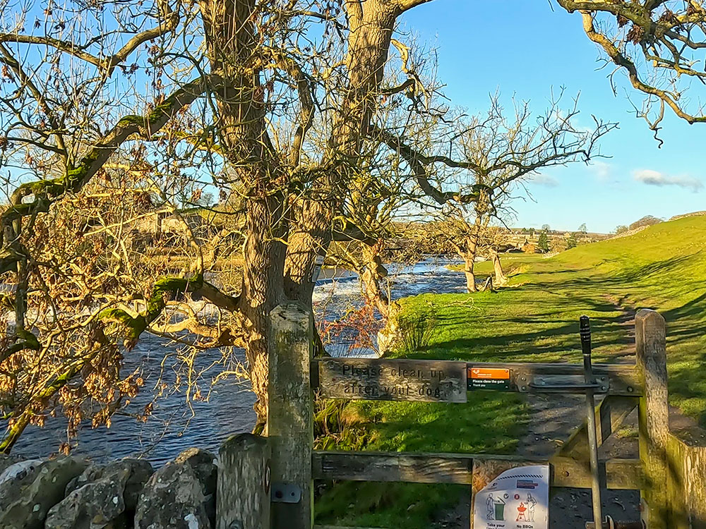 Wooden gate heading onto the riverside path at Linton Falls