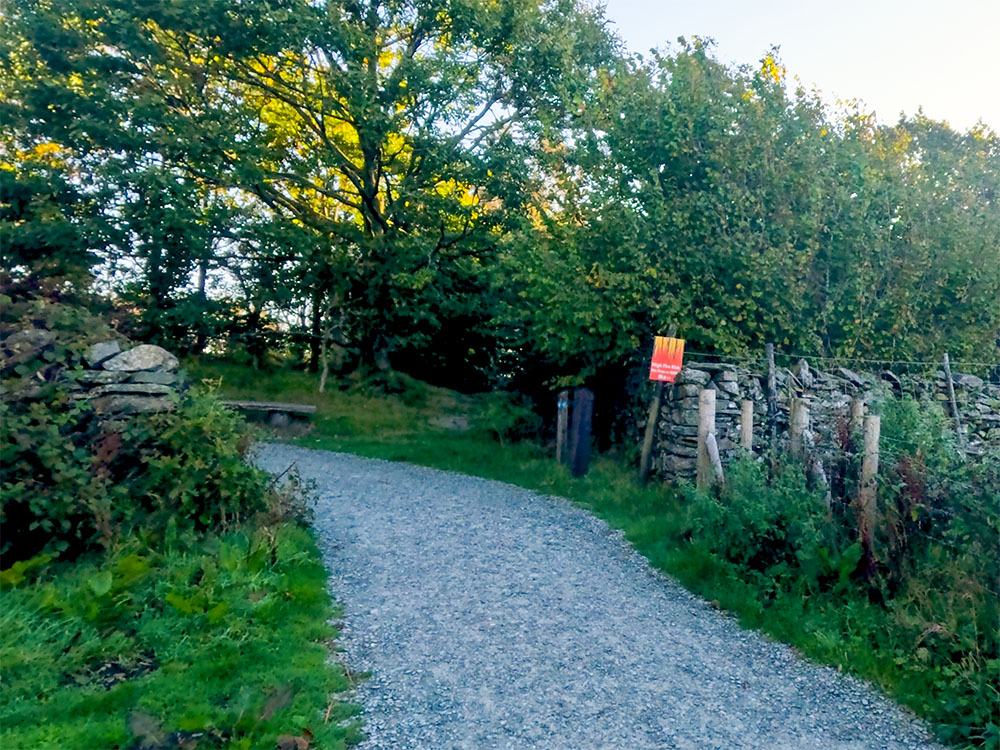 The gravelled path passes through a gap in the wall