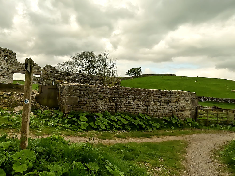 Footpath junction by building ruins at Meldings Barn