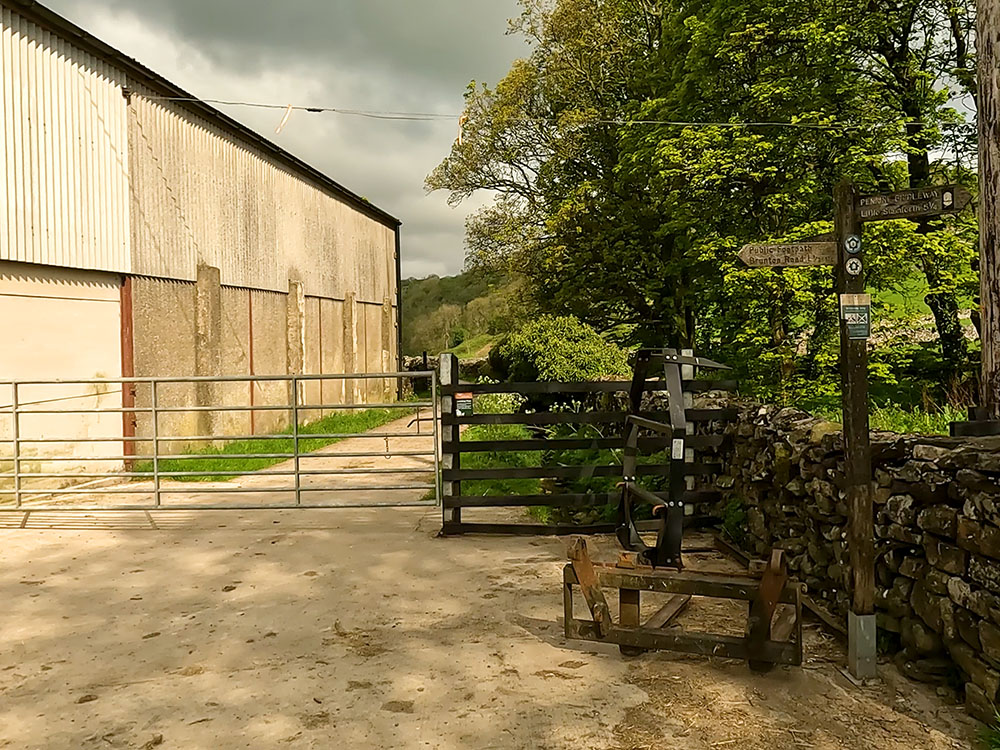 Path heading down the side of the farm building at Feizor along Hale Lane