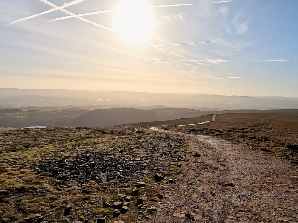 Starting the descent along the wide path across the top of Pendle Hill