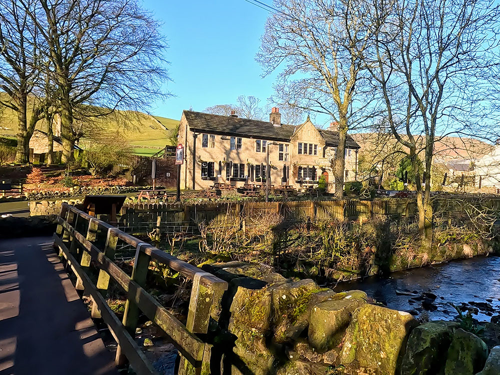 Footbridge, stream and Pendle Inn