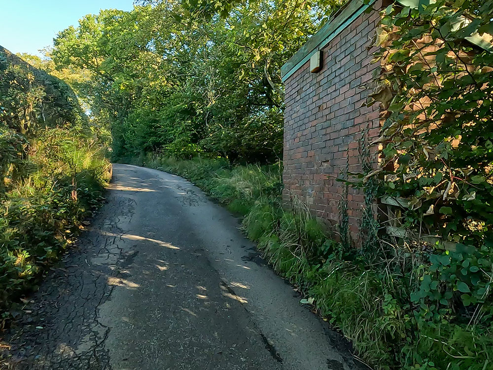 Approaching the red brick building behind which the Pendle Way footpath heads on the Pendle Witches Walk