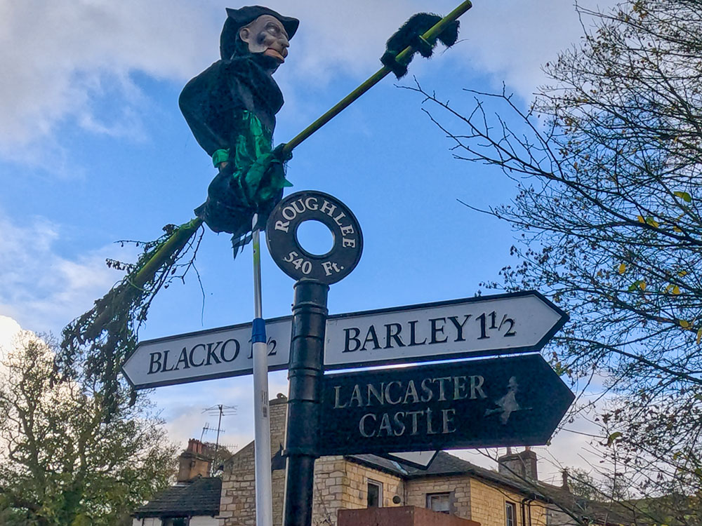 A witch on a broomstick on the Lancaster sign in Roughlee