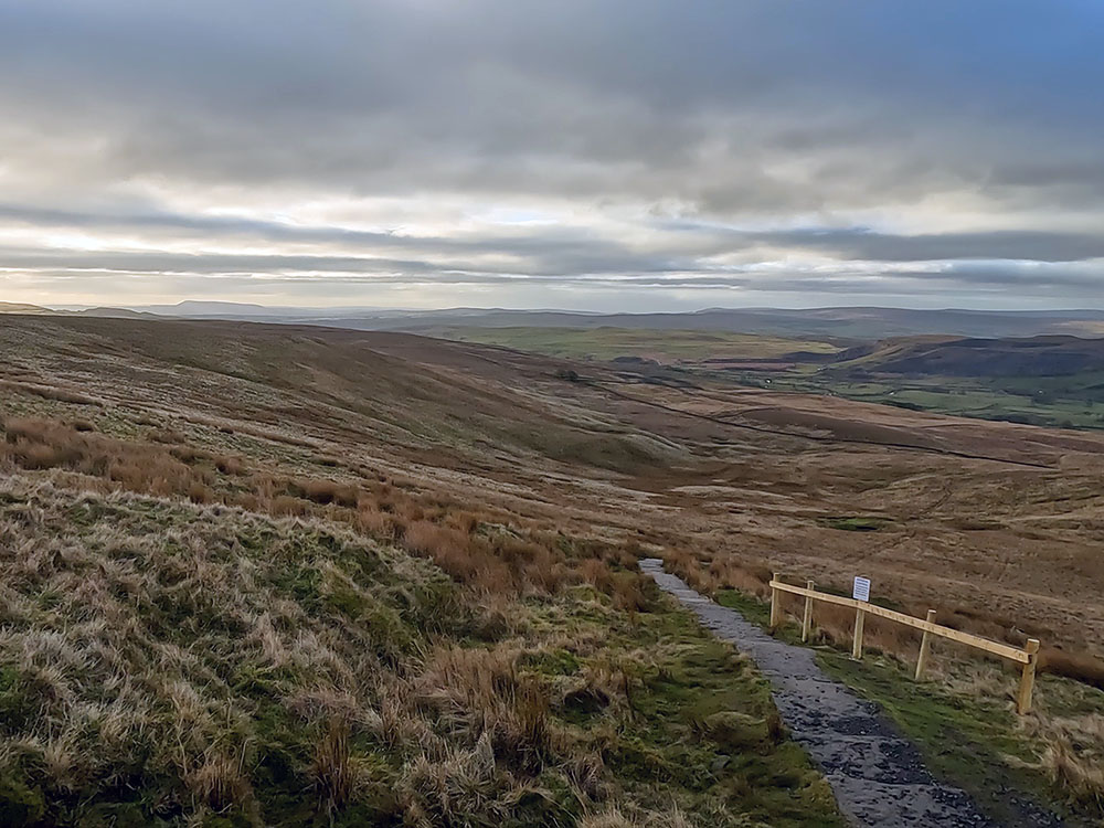 Looking back down the path to Pen-y-ghent with Pendle Hill on the horizon