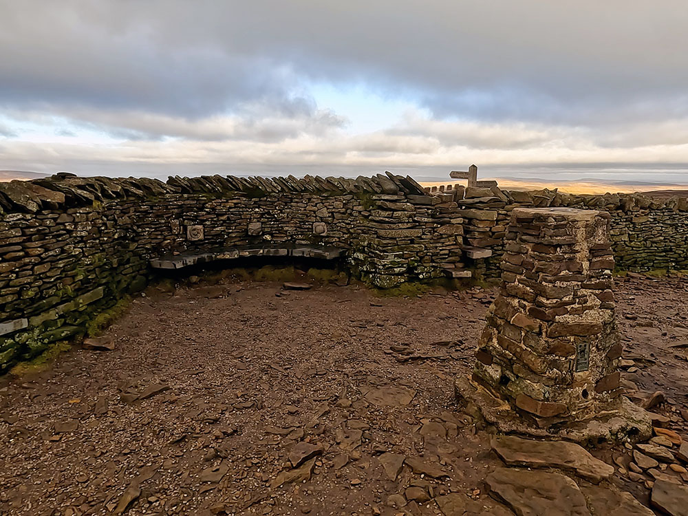 Trig Point and seat weather shelter on the summit of Pen-y-ghent