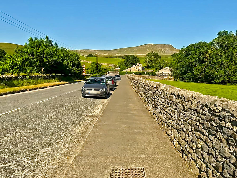 Heading along the pavement with Pen-y-ghent ahead on the horizon