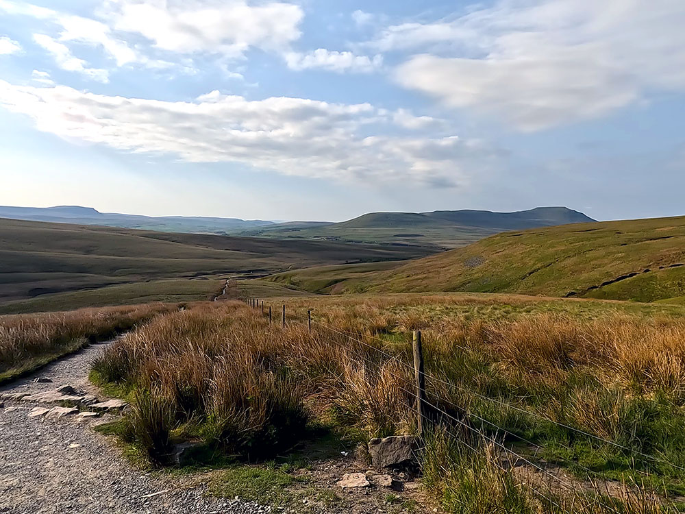 Looking back down the path from the signpost towards Pen-y-ghent and Ingleborough on the horizon