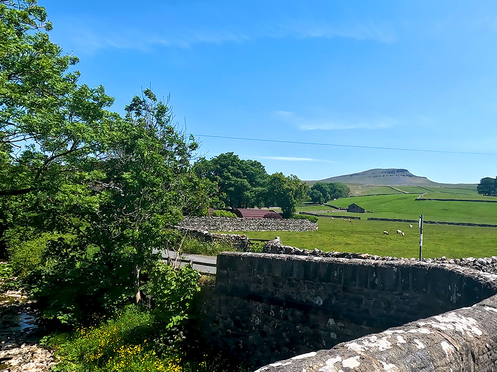 The road heading over Horton Bridge with Pen-y-ghent in the background