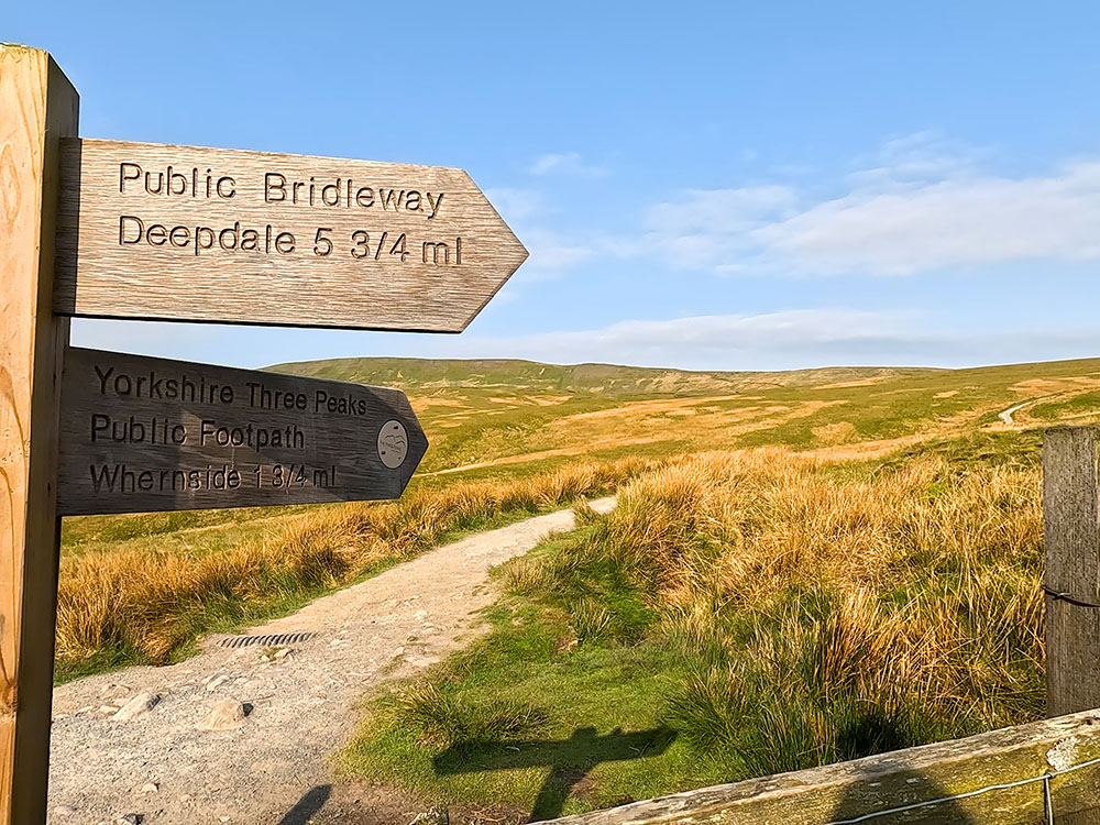 Yorkshire Three Peaks footpath sign pointing towards Whernside as the path leaves the Dales High Way