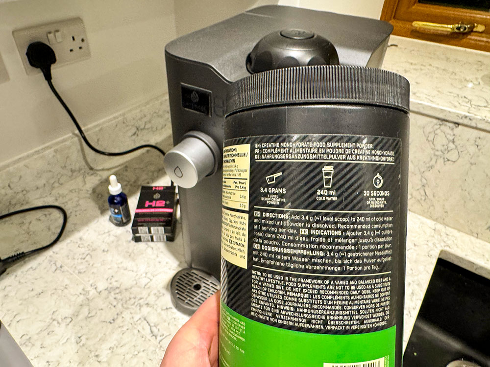 Close-up of hands holding an unbranded supplement tub and checking the back label